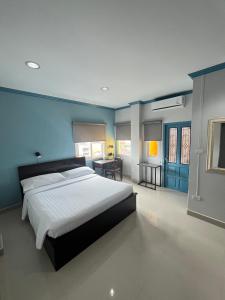 a bedroom with a large bed and blue walls at Garden Hill Hotel in Trang