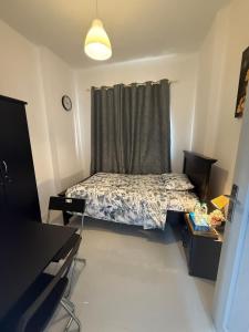 Un dormitorio pequeño con una cama y una ventana. en Flora Residence, en Abu Dabi