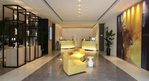un hall d'entrée avec un canapé jaune et un magasin dans l'établissement Jinjiang Metropolo Shanghai Xujiahui Nanhuating Hotel, à Shanghai