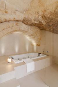 bañera en una habitación con techo de piedra en I Tre Portali Luxury Suites en Matera