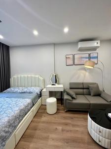 Phú ThúVinhomes Smart City - Lake View - Suzy Homes的带床和沙发的卧室