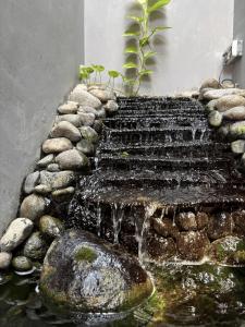 a water feature with stairs and rocks in a pond at Lora House in Sukoharjo +14 photos