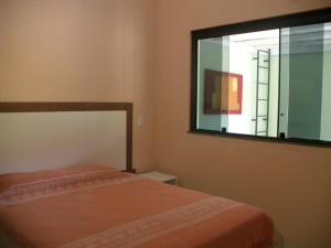 a bedroom with a bed and a large window at Jardim dos Sonhos in Santo Antônio do Leite