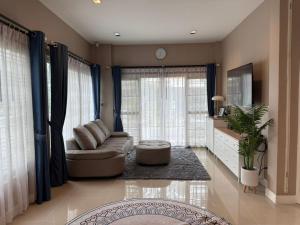 a living room with a couch and a table at Ssara house near suvannabhumi airport in Ban Khlong Prawet