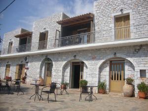 een gebouw met stoelen en tafels ervoor bij Kafiona Guesthouse in Pirgos Dhirou