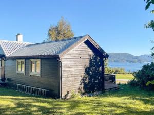 a small house in the grass with a lake in the background at 3 person holiday home in Frei-By Traum in Frei