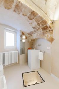 uma casa de banho com um WC branco e um tecto de pedra em I Tre Portali Luxury Suites em Matera