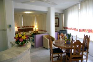 un soggiorno con tavolo e una sala da pranzo di Hotel Suites Jazmín Acapulco ad Acapulco