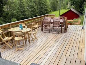 a wooden deck with a table and chairs on it at 8 person holiday home in Lindesnes in Tryland +26 photos