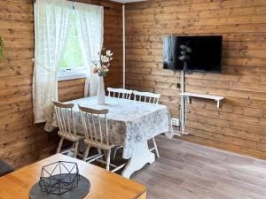 a dining room with a table and chairs and a television at 3 person holiday home in Flatraket-By Traum in Barmen