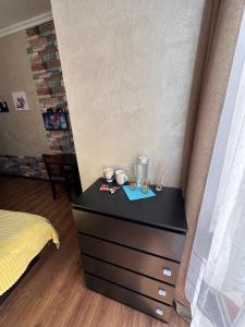 a black dresser in a room with a bed at Glori in Tbilisi City