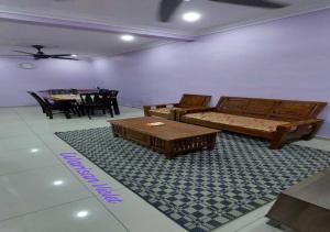 a living room with a bed and a table at Homestay Warisan Violet Tg Minyak in Malacca