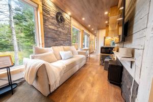 a living room with a couch in a tiny house at Spa & River view - Le Conteneur Cache in Saint-Just-de-Bretenières +54 photos