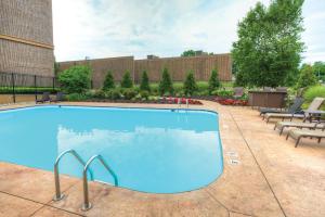 a large swimming pool with chairs and a building at Radisson Hotel Freehold in Freehold