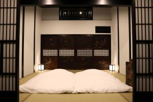 a white bed in a room with two lights at 辰巳屋 Tatsumiya in Osaka +104 photos