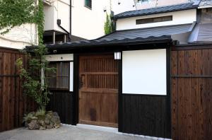 a house with two garage doors and a fence at 辰巳屋 Tatsumiya in Osaka