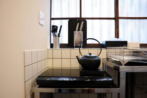 a black tea kettle on a stove in a kitchen at 辰巳屋 Tatsumiya in Osaka