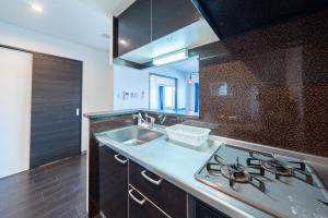 een keuken met een spoelbak en een fornuis bij AROMA in Sapporo