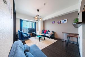een woonkamer met een blauwe bank en een tv bij AROMA in Sapporo +89 foto's