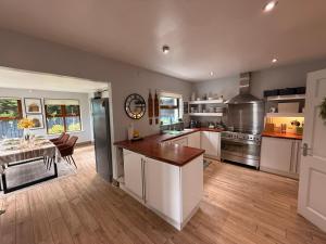 a kitchen with white cabinets and a table in it at Foyleview Point in Balnacart