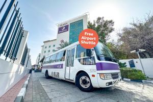 a bus parked on a street with a free airport shuttle sign on it at Premier Inn Dubai International Airport - An Emirates Group Company in Dubai