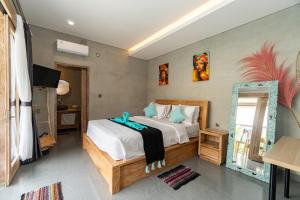 a bedroom with a bed and a mirror at Villa Alam Kita in Ubud