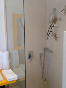 ein Bad mit einer Dusche, einem WC und Handtüchern in der Unterkunft flamboyant in Marigot