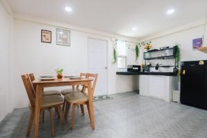 a kitchen with a table and chairs and a refrigerator at Free Netflix 3BR 10 Mins to City Center 3 Mins 7-11 in Hat Yai