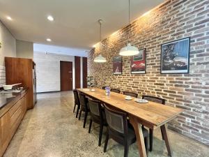 une cuisine et une salle à manger avec un mur en briques dans l'établissement Cove Heritage, à Binong