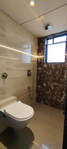 a bathroom with a toilet and a window at Eco Wind in Lonavala +20 photos