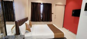 a bedroom with a bed and a red wall at Eco Wind in Lonavala