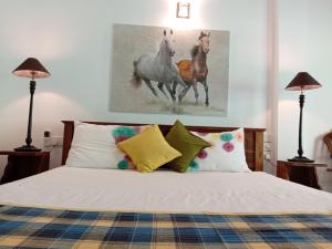a bedroom with a bed with two horses painting on the wall at Ceylonika Rest in Bentota +40 photos