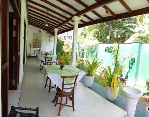 a patio with tables and chairs and plants at Ceylonika Rest in Bentota