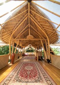a large room with a rug on a wooden floor at Villa Kesambi in Gili Air