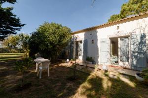 Chambres D'hôtes في Alónya: منزل أبيض مع طاولة وكراسي في الفناء