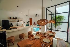 タナロットにある'Villa Vivid' 2BR Bohemian, 5 min to Kedungu Beachの木製のテーブルと椅子のあるキッチンとダイニングルーム