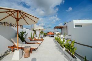 タナロットにある'Villa Vivid' 2BR Bohemian, 5 min to Kedungu Beachのパティオ(椅子、パラソル付)