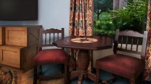 a wooden table with two chairs and a table with a tv at Disney's Caribbean Beach Resort in Orlando