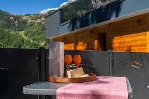 une table avec deux verres à vin sur le toit d'un bâtiment dans l'établissement MAISON DI VOLPI - Il fascino della montagna, la comodità del centro, à Courmayeur