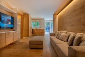 un salon avec un canapé et une télévision à écran plat dans l'établissement MAISON DI VOLPI - Il fascino della montagna, la comodità del centro, à Courmayeur