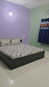 een bed in een kamer met een paarse muur bij 2 BHK Huge House on 1st Floor in Marwad