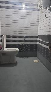 een badkamer met een toilet en een fiets aan de muur bij 2 BHK Huge House on 1st Floor in Marwad
