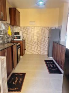 Una pequeña cocina con gabinetes de madera y una estufa. en Lawrence place, en Nairobi