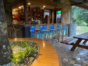 a restaurant with chairs and a table and a bar at B&R Hostel in Puerto Princesa City