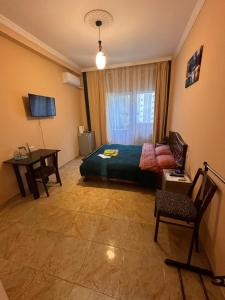 een slaapkamer met een bed, een tafel en een bureau bij Glori in Tbilisi City