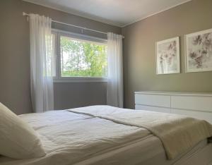 a bedroom with a large bed with a window at Guest house with sauna and private beach in Inkoo