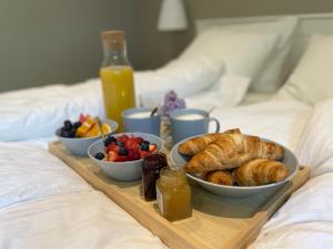 a breakfast tray with pastries and fruit on a bed at Guest house with sauna and private beach in Inkoo