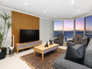 a living room with a tv and a couch and a table at Sandy Shores On Beach - 709 in Strand
