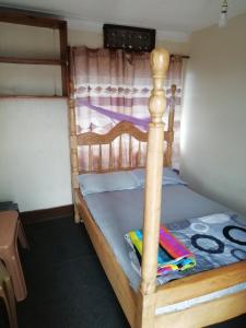 カンパラにあるWomen massage and guest houseのベッドルーム1室(木枠の二段ベッド1組付)