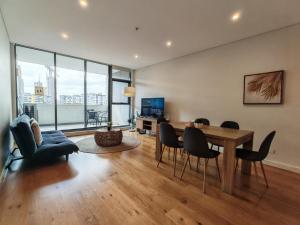 a living room with a wooden table and chairs at 2BR apt close to MQ shopping centre and university in Sydney